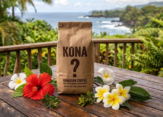 a generic coffee bag with the word KONA on it and below, a large question mark. The bag is sitting on a dark teak table in Hawaii with a few tropical flowers scattered around it