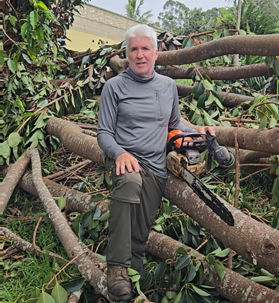 Kona Earth coffee farmer Steve Wynn cleans up fallen trees after the storms in Hawaii