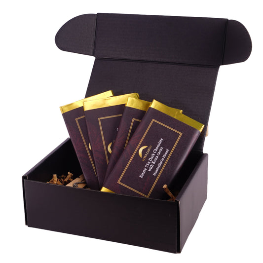 Black gift box with gold-trimmed chocolate bars on a white background